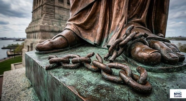 Broken chains and shackles at the feet of the Statue of Liberty